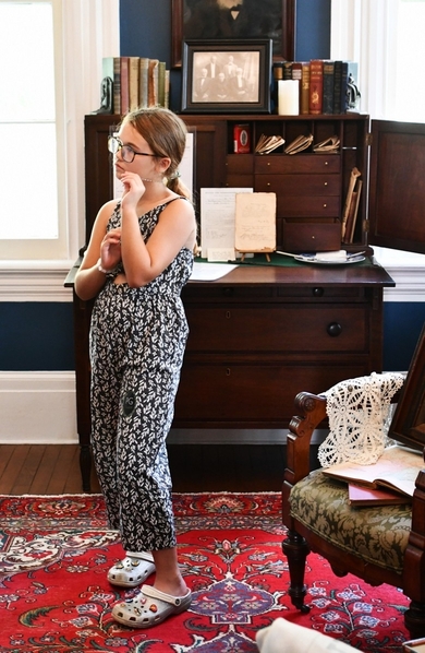 Young guest listens about enslaved persons in the office