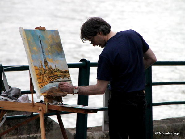 Street artist by the Seine, painting the Eiffel Tower