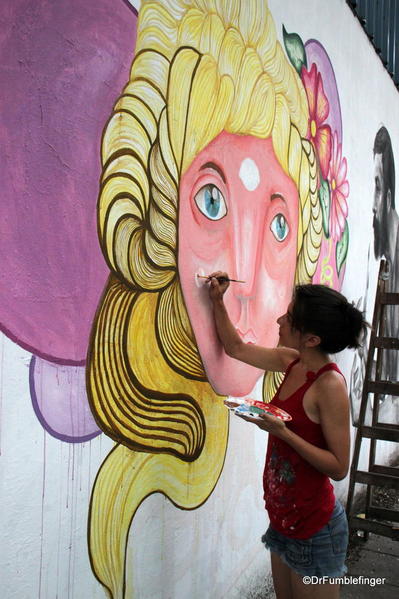 Artists creating street art on Charcarita walls.