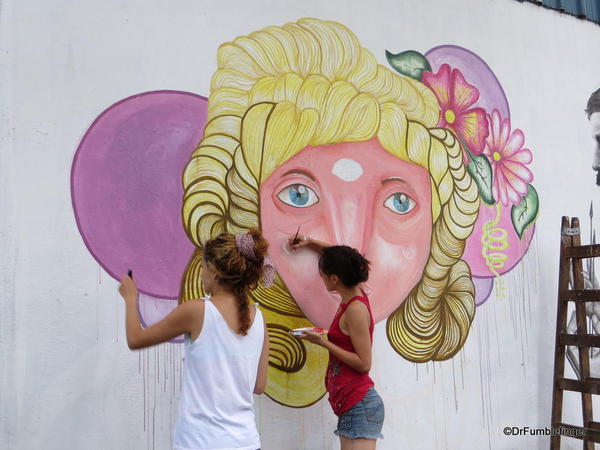 Artists creating street art on Charcarita walls.